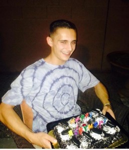 Celebrating his eighteenth birthday, Kennedy , 12, poses for his birthday photo before cutting his cake.
