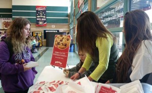 Seniors, Courtney Hughes, Lauren Abercrombie, and Caroline Teixeira, sell cookies during second lunch to Nicole Norad, 10. Photo by Saveria Farino