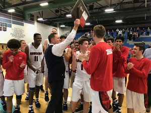 After their big win, the Cougars and Coach Kaufman celebrate with their new plaque. Photo courtesy of Mr. Piccininni