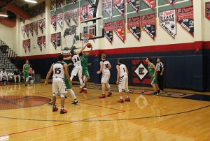 During Tuesday night’s game, Jake DesJardins, 12, surges forward to block a jump shot while juniors Bryce Savoy, Kennedy Koehler, and Trey Hurlburt stand guard. Photo by Karen Pegueros