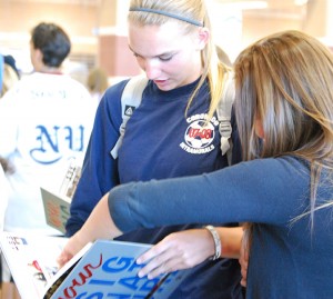 Taylor Kornieck, sophomore, looks at her yearbook with her friend Makayla Putman,sophomore, at the yearbook signing party. (Photo by Jolie Ross)