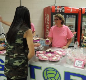 Purchasing a pink cupcake at the Dig Pink vollyball game, Andrea Yuen, freshman, shows her support for the cause. (Photo by Kacie Leach)