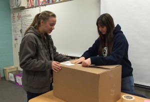 Sealing the final box, juniors Sarah Litto and Olivia Smith prepare their shipment for Operation Christmas Child. Photo by McKenna Cooley 