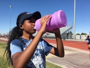 After running four miles at Monday’s track practice, Tori Williams, 11, guzzles water to rehydrate and avoid heat exhaustion. Photo by Karen Pegueros