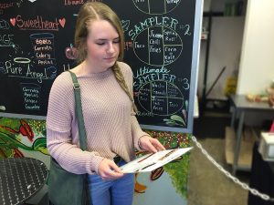 In front of the Simply Pure specials board, Kaylee Heiny, 10, scans the menu, pondering which of the vegan options she should eat for lunch. Photo by Sage Tippie