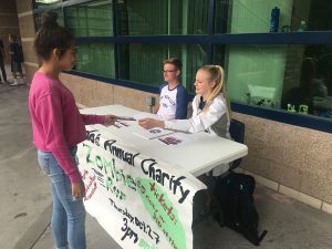 While buying a ticket for the Zombie Run, AP Executive Council members Shelby Burdo, 12, and Sean Maseng, 9, explain the rules to Valeria Handlos, 11. Photo by Karen Pegueros