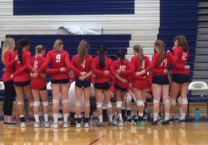 Varsity volleyball huddles, while talking to their coach, during one of their timeouts in their game against Silverado. Photo by Maddie Baker