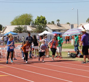 TaTeonna Hass, freshman, and her peer buddy, Makynna Meegan, sophomore, begin to run in a track event during the Special Olympics on May 2 at Cheyenne High School against other students from Clark County School District.  (Photo by Jessica Wilson) 