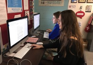 Journalism II staff members Paula Dispa, 11, and Joshua Christensen, 9, work diligently to complete their pieces for the school website, “The Roar.” Photo by Ryan Kelleher 