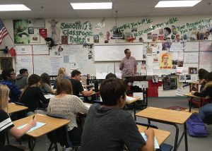 While checking over his papers, Mr. Johnson prepares his lesson to enlighten students with fun facts about history. Photo by Saveria Farino