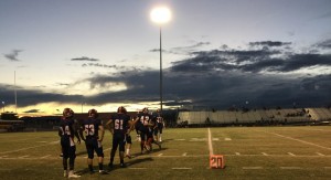 As the sun sets, the varsity football prepares for their game, one of Beau Edwards’, 12, most memorable moments of high school. Photo by Ryann Heinlen