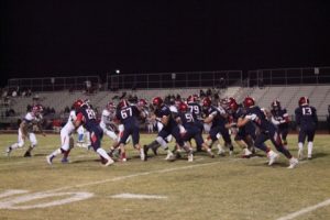 To a achieve a victory over Valley High School, the varsity football team works hard to defend the ball. Photo by Sage Tippie