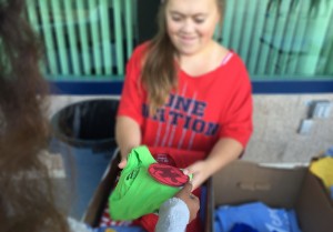 During second lunch, Caroline Teixeira, 12, sells Katelyn Virgen, 9, an Aces for Autism t-shirt and puzzle piece to raise money in honor of Autism Awareness month. Photo by Sage Tippie