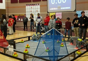 Robotics team, on the blue mat, prepares to face off against the first seeded alliance, on the red mat, during a semi-final match. Photo by Leanne Messimer