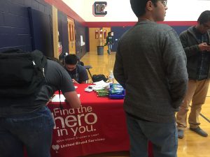 Based on their time slot, students check in on the sign-in sheet and wait to donate in the auxiliary gym. Photo by Lexi Lane