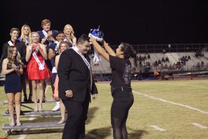 Student Council member Nikki Hadighi,12, crowns the Homecoming king, Dyan Ziegler, 12, during halftime. Photo by Saveria Farino