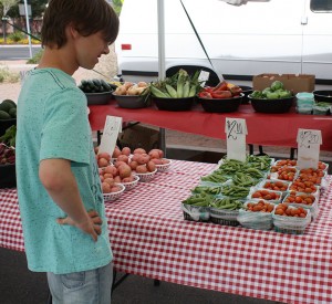 Keenan Davis, sophomore, shopping for fruits and vegetables to fill produce baskets with at the local farmers’ market on May 9.  (Photo by Kacie Leach)  
