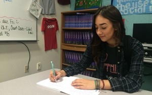 Working on her English writing assignment, Reilly Scott, senior, wears her Pura Vida bracelets in honor of multiple charities she supports on a daily basis. Organizations such as sea animals, depression, selfharm, and others are represented by the multiple different colors of bracelets on her wrist. 