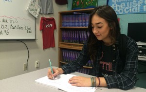 Working on her English writing assignment, Reilly Scott, senior, wears her Pura Vida bracelets in honor of multiple charities she supports on a daily basis. Organizations such as sea animals, depression, selfharm, and others are represented by the multiple different colors of bracelets on her wrist.