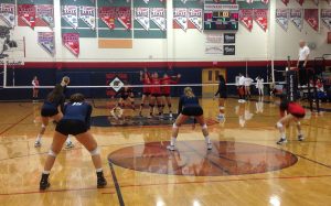Women’s varsity volleyball gets in formation to defeat Liberty during the third period of the first home game. Photo by Saveria Farino
