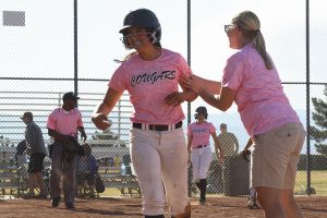 After running to home base during the Strike Out Cancer game, Taylor Okamura gets congratulated by Coach Krueger. Photo by Giana Haynia.